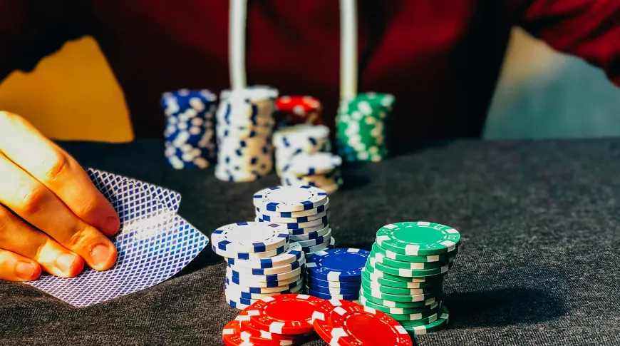 Poker Cassino Online - Uma mesa com cartas e fichas de poker com uma pessoa jogando